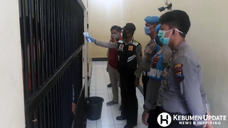 Paurkes Polres Kebumen Aiptu Agus Sunani mengecek suhu tubuh tahanan. (Foto: Dok. Polres Kebumen)