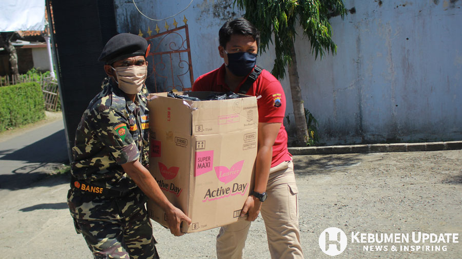 Polisi bersama Banser mengangkat barang bantuan. (Foto: Padmo-KebumenUpdate) 