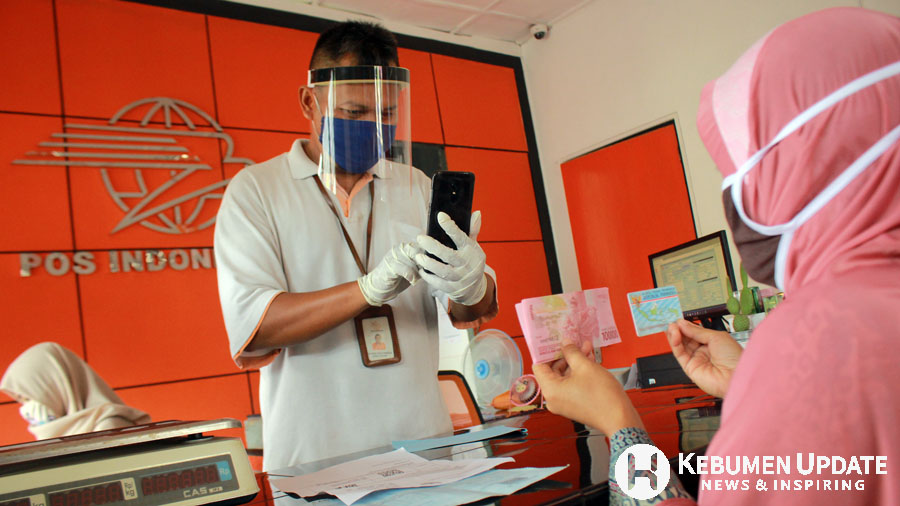 Petugas Kantor Pos Sruweng mengambil gambar penerima BNT. (Foto: Padmo-KebumenUpdate)