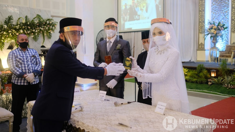 Kedua mempelai mengenakan masker dan face shield. (Foto: Istimewa)