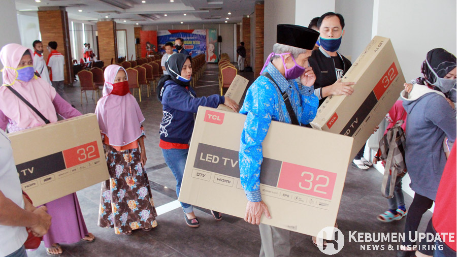 Para pelanggan membawa pulang hadiah televisi. (Foto: Padmo-KebumenUpdate)