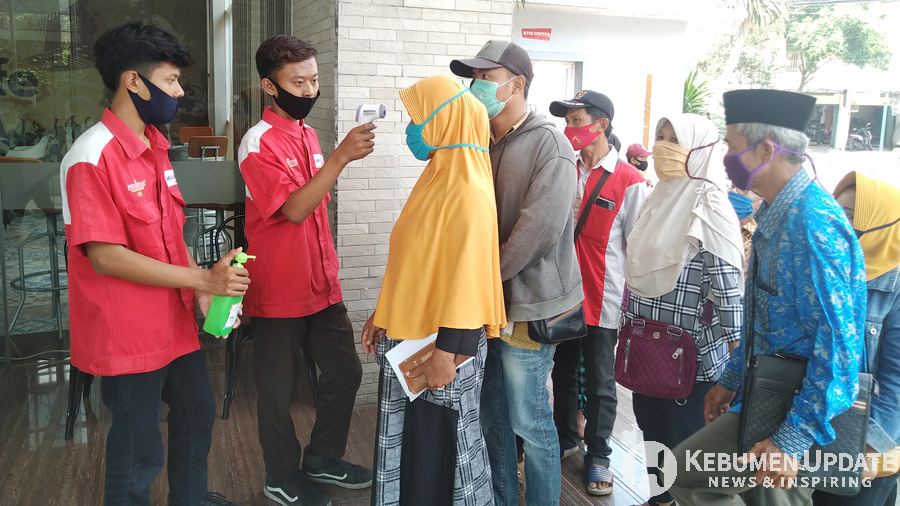 Pelanggan satu per satu dicek suhu tubuhnya. (Foto: Padmo-KebumenUpdate) 
