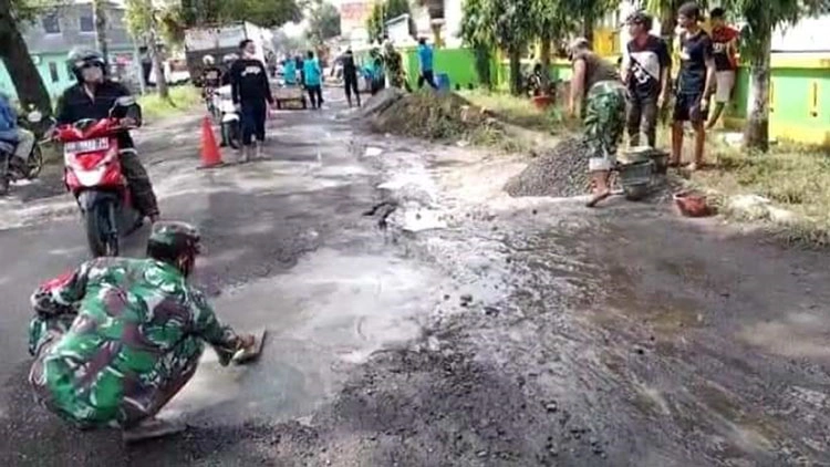 Anggota TNI, Polisi bersama warga memperbaiki jalan rusak. (Foto: Istimewa)