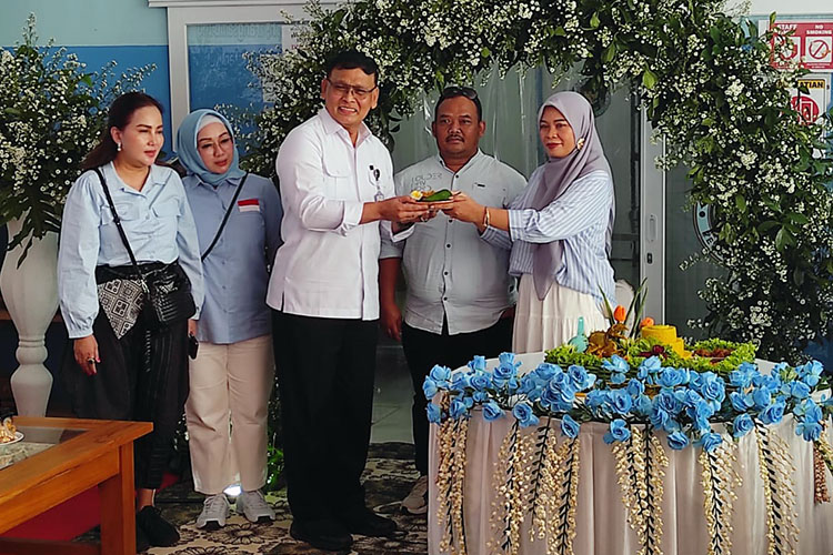 Brigjen TNI (Purn) Syahnan SE MM menerima potongan tumpeng. (Foto: Padmo)